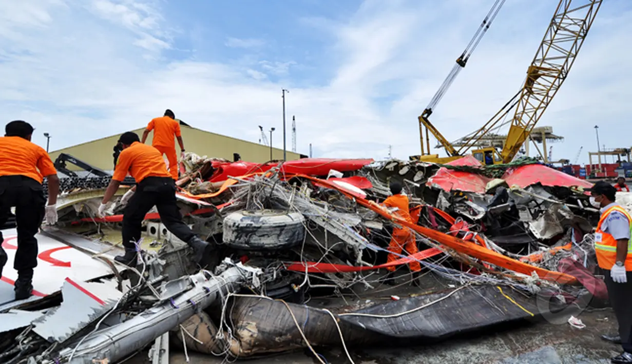 Petugas Basarnas segera memeriksa bangkai badan pesawat Airasia QZ8501 usai dipindahkan dari kapal milik SKK Migas, Crest Onyx, Pelabuhan Tanjung Priok, Jakarta, Senin (2/3/2015).  (Liputan6.com/Faizal Fanani)