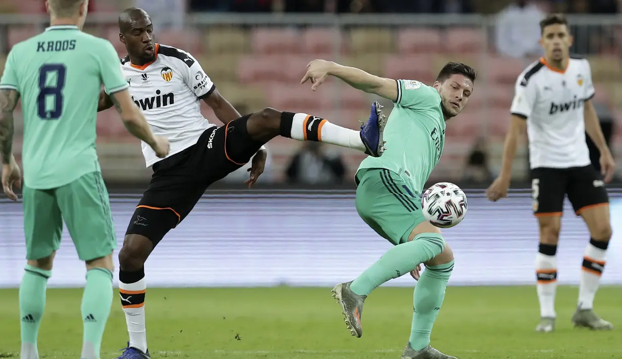 Gelandang Valencia, Geoffrey Kondogbia berebut bola dengan penyerang Real Madrid, Luka Jovic pada pertandingan semifinal Piala Super Spanyol di stadion King Abdullah di Jiddah, Arab Saudi, Rabu, (8/1/2020). Hasil ini membua Real Madrid melaju ke final Piala Super Spanyol. (AP Photo/Hassan Ammar)
