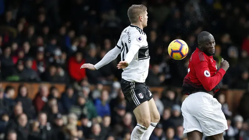 Striker Manchester United, Romelu Lukaku, duel udara dengan bek Fulham, Maxime Le Marchand. (AFP/Ian Kington)