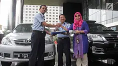 Plt Koordinator Unit Kerja Labuksi KPK Irene Putri menyerahkan barang sitaan ke Direktur Pelayanan Tahanan dan Pengelolaan Benda Sitaan dan Barang Rampasan Negara Wahidin di Gedung KPK Jakarta, Selasa (30/1). (Liputan6.com/Herman Zakharia)