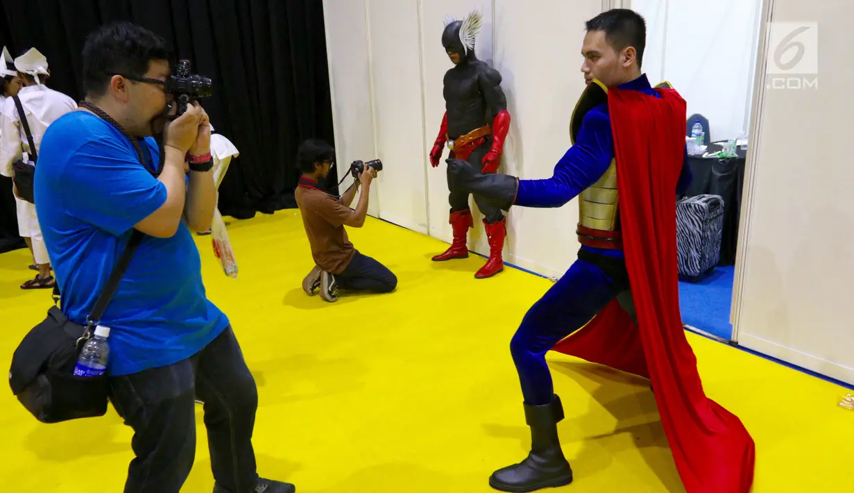 Pengunjung sedang mengambil foto aksi seorang cosplayer pada acara  Festival Popcon Asia 2017 di JCC, Jakarta, Minggu (6/8). Festival yang berlangsung selama 2 hari dan diikuti kreator dari dalam dan luar negeri. (Liputan6.com/Fery Pradolo)