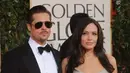 Angelina Jolie dan Brad Pitt di foto ini tampak elegan. Pitt dengan setelan jas dan kaca mata hitamnya begitu gagah, dan Jolie yang tampil dengan rambut terurainya. (AFP/Robyn Beck)