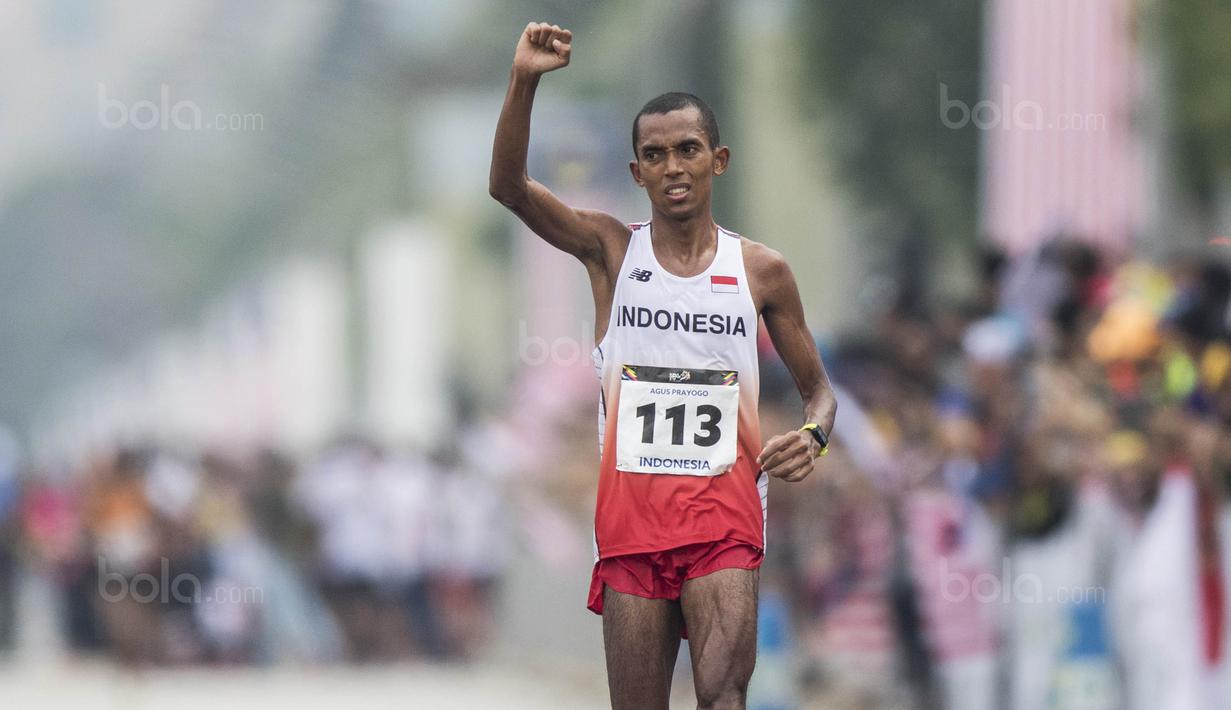 Pelari Indonesia, Agus Prayogo, melakukan selebrasi usai tampil pada nomor marathon SEA Games di Putrajaya, Kuala Lumpur, Sabtu (19/8/2017). Agus meraih medali perak dengan waktu dua jam 27 menit 16 detik. (Bola.com/Vitalis Yogi Trisna)