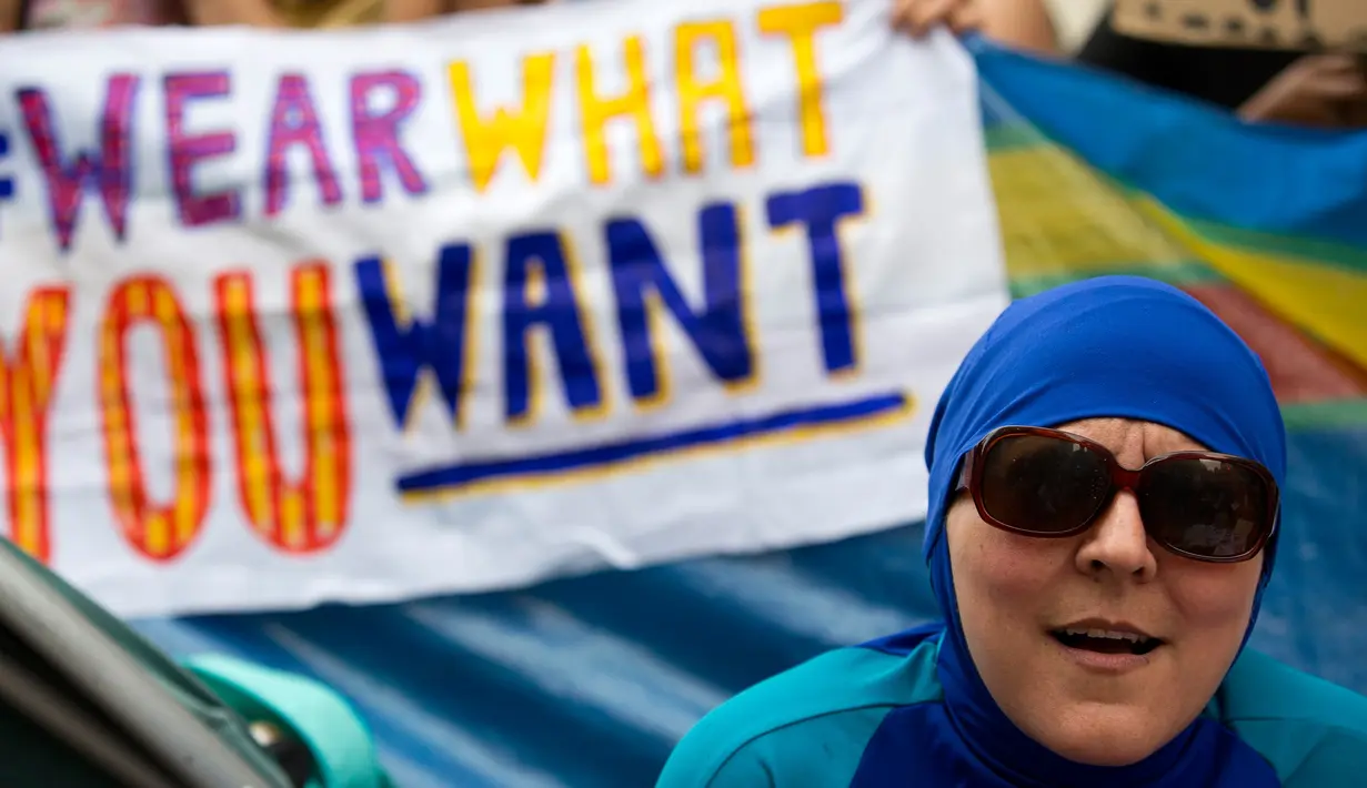 <p>Seorang wanita mengenakan burkini ketika mengadakan demonstrasi pesta pantai di luar kedutaan Prancis di London, Inggris, Kamis (25/8). Mereka memprotes larangan burkini yang diberlakukan di beberapa kota pesisir di Prancis. (AFP PHOTO/JUSTIN Tallis)</p>