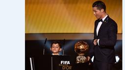 Cristiano Ronaldo didampingi anaknya, Cristiano Jr, saat menerima trofi FIFA Ballon d'Or sebagai pemain terbaik dunia 2014. 12 Januari 2015. (AFP/Fabrice Coffrini)