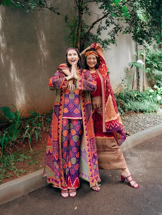 Kakak beradik Maudy Ayunda-Amanda Khairunnisa memilih penampilan boho yang unik di Hari Lebaran. Maudy Ayunda mengenakan setelan atasan dan celana panjang, serta outer panjang bermotif semarak. Sedangkan sang adik Amanda memilih atasan dan rok, serta outer yang juga bermotif semarak. [Foto: Instagram/maudyayunda]