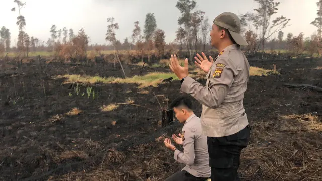 Anggota polisi Satgas Karhutla sujud syukur hujan turun.