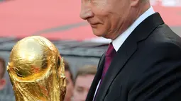 Presiden Rusia Vladimir Putin membawa trofi Piala Dunia FIFA di Stadion Luzhniki, Moskow (9/9). Piala Dunia 2018 akan dimulai di stadion Luzhniki pada 14 Juni 2018. (Mikhail Klimentyev, Sputnik, Kremlin Pool Photo via AP)