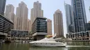 Sebuah kapal pesiar mewah terlihat di Dubai Marina Beach, emirat Teluk pada 10 Juni 2021. Di tengah aturan pandemi di mana warga harus menjaga jarak dan menghindari keramaian, orang-orang kaya di Dubai memiliki cara untuk bisa pergi berekreasi, yaitu mode wisata kapal pesiar. (Karim SAHIB/AFP)