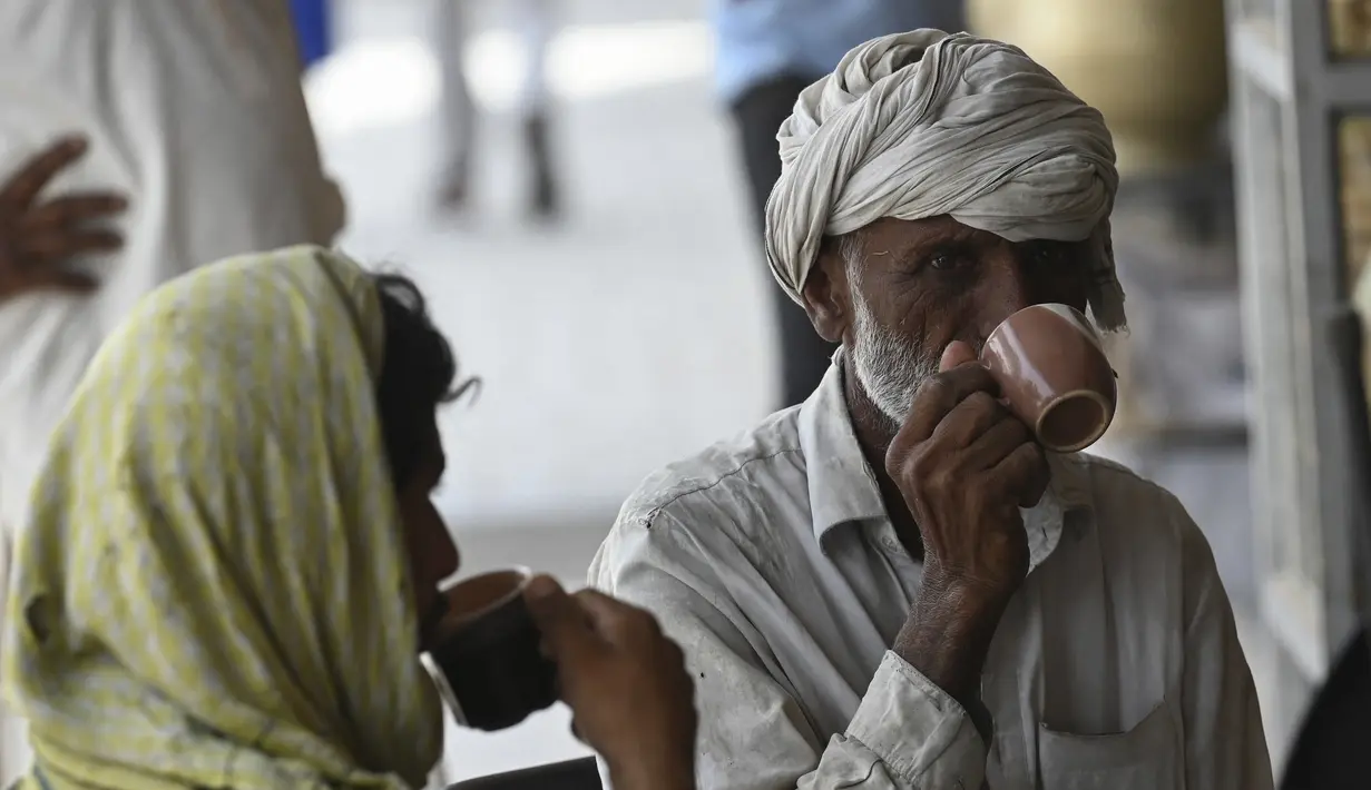 Pria Pakistan meminum secangkir teh di sebuah restoran di Islamabad, Rabu (15/6/2022). Pakistan telah menghadapi tantangan ekonomi yang parah selama berbulan-bulan, yang menyebabkan kenaikan harga makanan, gas dan minyak. (Aamir QURESHI / AFP)