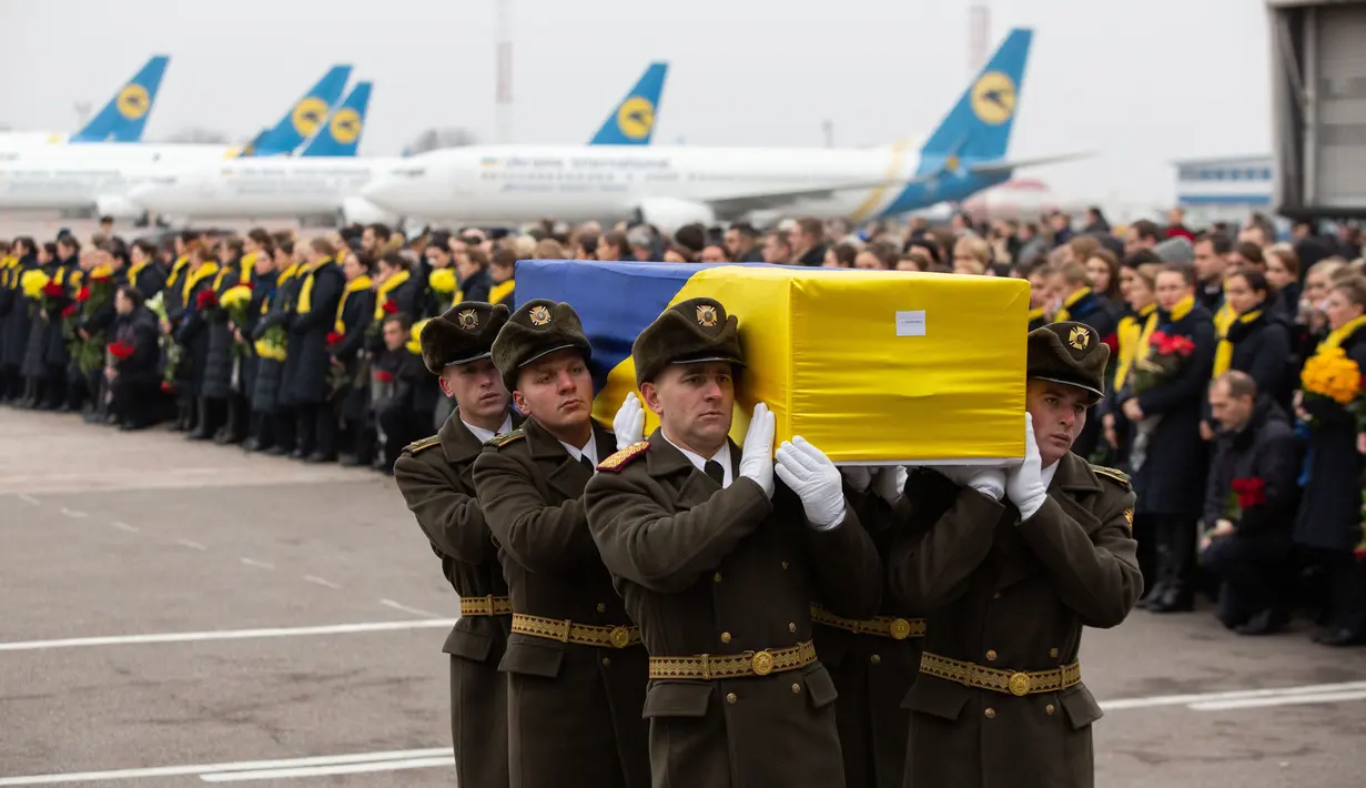 Prajurit Penjaga Kehormatan membawa jenazah 11 warga Ukraina yang tewas dalam insiden jatuhnya pesawat Ukraine International Airlines di Iran (8/1) lalu, Bandara Boryspil Kiev, Ukraina, Minggu (19/1/2020). 176 penumpang dan awak tewas dalam tragedi tersebut.(Ukrainian Presidential Press Service/AFP)