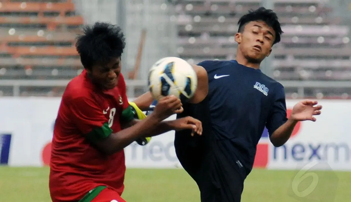Gelandang timnas U-19 Indonesia, M Rafif Putra Adri menghindari terjangan salah satu pemain timnas U-19 Singapura saat berlaga di Stadion GBK Jakarta, (8/12/2014). Indonesia unggul 1-0 atas Singapura. (Liputan6.com/Helmi Fithriansyah)