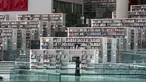Seorang wanita melihat-lihat koleksi buku di Perpustakaan Nasional Qatar di ibu kota Doha pada 19 Mei 2019. Bangunan megah karya arsitek Rem Koolhaas ini memiliki luas 45 ribu meter persegi. (KARIM JAAFAR / AFP)