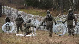 Tentara Polandia mulai memasang penghalang kawat berduri di sepanjang perbatasan Polandia dengan eksklave Rusia, Kaliningrad di Wisztyniec, Polandia, Rabu (2/11/2022).  Pagar kawat berduri tersebut dibangun di tengah kekhawatiran bahwa Kaliningrad sebagai daerah kantong mungkin menjadi saluran untuk migrasi ilegal. (AP Photo/Michal Kosc)