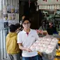 Martin Kwok berpose bersama roti keberuntungan di depan toko legendarisnya, Kwok Kam Kee Cake Shop, di Cheung Chau, Hong Kong. (Liputan6.com/Asnida Riani)