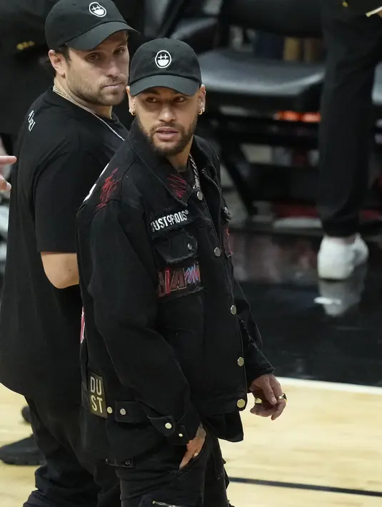 Neymar tampil keren mengenakan jaket Jimmy Butler untuk menunjukkan dukungannya saat berjalan di lapangan basket. Beberapa penggemar NBA mengungkapkan kekaguman mereka terhadap jaket yang dikenakan Neymar. (AP Photo/Wilfredo Lee)