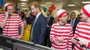Ekspresi lucu Pangeran Harry saat ambil bagian menjadi broker dalam acara amal tahunan ICAP di London, Rabu (7/12). Pangeran Harry menjadi broker dadakan untuk mengumpulkan dana amal dari 60 kantor di seluruh dunia. (REUTERS/Geoff Pugh/Pool)