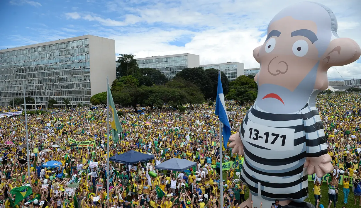 Kubu oposisi membawa balon raksasa dalam unjuk rasa menuntut pengunduran diri Presiden Dilma Rousseff di Esplanada dos Ministerios, Brasil, Minggu (13/3). (Andressa Anholete / AFP)