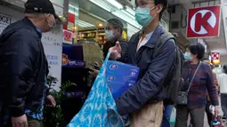 Seorang pria dengan mengenakan masker wajah seusai membeli kertas tisu di luar apotek di Hong Kong, Kamis (6/2/2020). Di tengah kelangkaan masker wajah untuk melindungi terhadap wabah virus corona, tisu toilet tiba-tiba juga menjadi salah satu barang yang langka di Hong Kong. (AP/Vincent Yu)