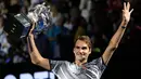 Petenis asal Swiss Roger Federer, memegang pialanya setelah mengalahkan Rafael Nadal asal Spanyol pada Final Australia Terbuka 2017 di Melbourne, Minggu (29/1). Gelar ini merupakan gelar Grand Slam ke-18 sepanjang kariernya. (AP Photo/Aaron Favila)