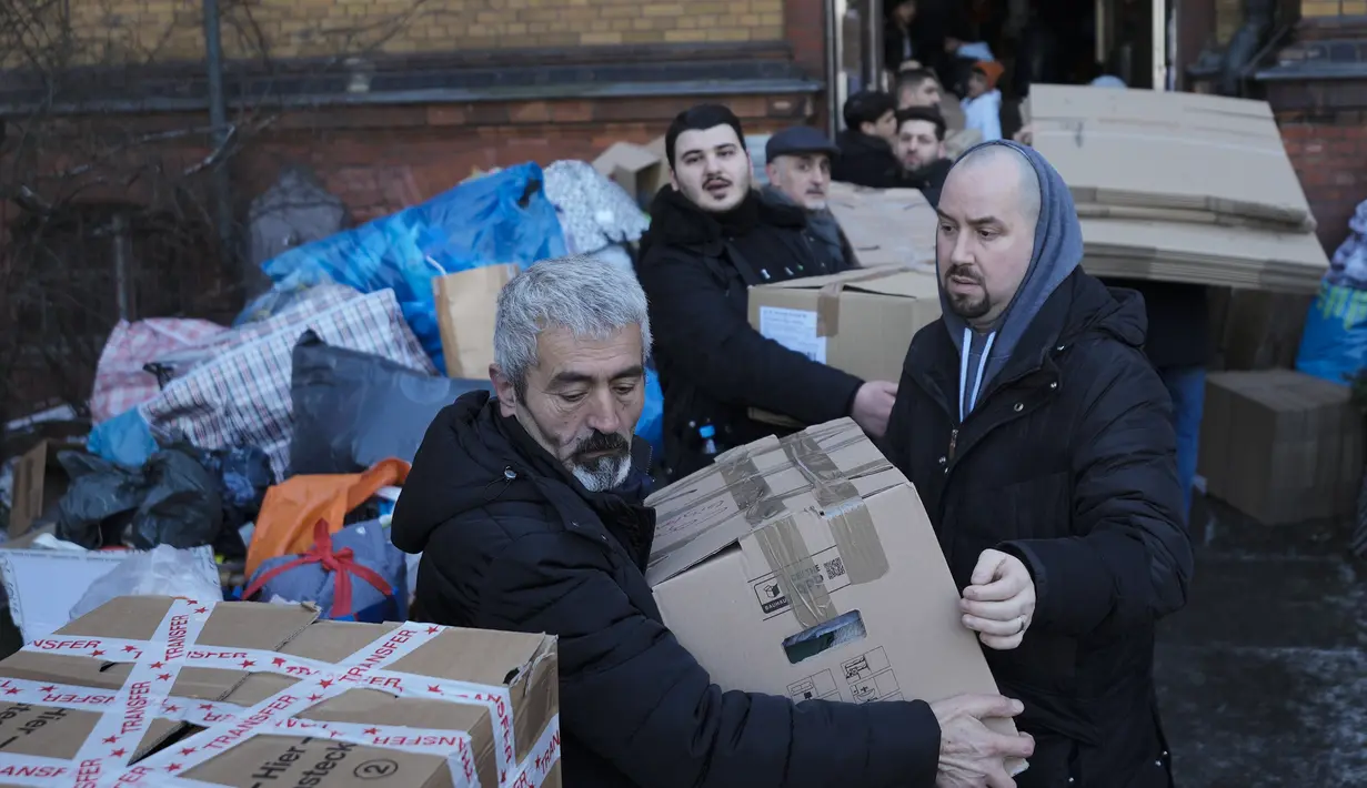 Orang-orang membuat rantai manusia untuk menumpuk kotak berisi persediaan bantuan di tempat pengumpulan komunitas Turki di Berlin, Jerman, Selasa, 7 Februari 2023. Ratusan anggota komunitas Turki Berlin berbondong-bondong ke sekolah musik di ibu kota Jerman untuk menyumbangkan bantuan kemanusiaan penting setelah Turki selatan dan Suriah utara dilanda gempa bumi ganda pada Senin, 6 Februari 2023. (AP Photo/Markus Schreiber)