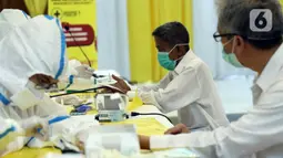 Petugas medis melakukan Rapid Test COVID-19 di DPP Partai Golkar, Jakarta, Rabu (8/4/2020). Rapid test dilakukan untuk memeriksa virus menggunakan antibodi IgG dan IgM yang ada di dalam darah, antibodi akan terbentuk di tubuh saat mengalami infeksi virus. (Liputan6.com/Helmi Fithriansyah)