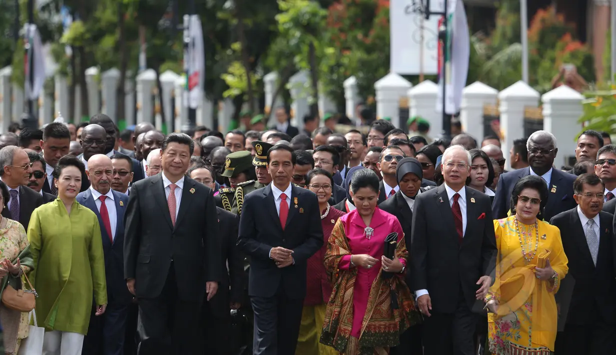 Presiden RI Joko Widodo (keempat kiri) didampingi Ibu Negara Iriana Joko Widodo (keempat kanan) dan para kepala negara dari Asia dan Afrika berjalan menuju Gedung Merdeka saat peringatan KAA di Bandung, Jumat (24/4/2015). (Liputan6.com/Herman Zakharia)