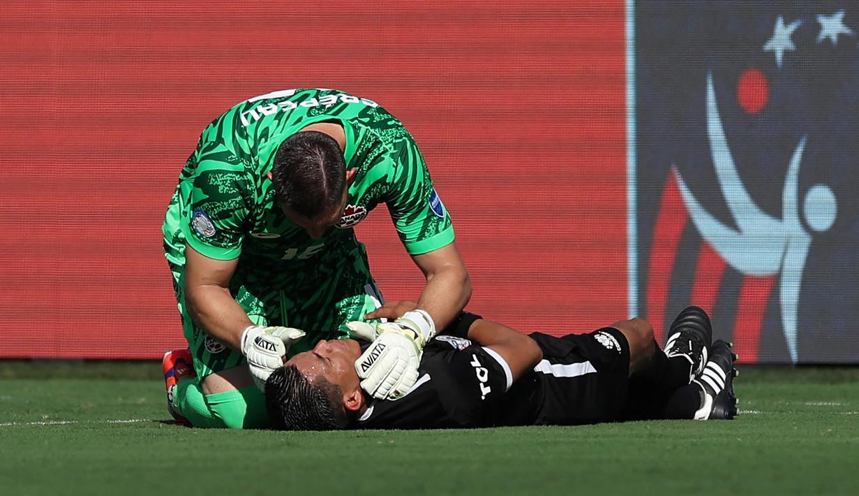 Kiper Kanada, Maxime Crepeau memberikan pertolongan kepada asisten wasit Humberto Panjoj saat mengalami pingsan pada laga Grup A Copa America 2024 antara Peru melawan Kanada di Children's Mercy Park, Kansas City, Kansas, Selasa (25/06/2024) waktu setempat. (AFP/Getty Images/Jamie Squire)