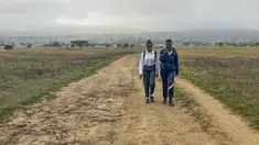 Luyanda Hlali (kiri) dan temannya Mimi Dubazane memulai rutinitas berjalan kaki selama 2 jam dari desa Stratford ke sekolah mereka di Dundee, Afrika Selatan, Kamis, 26 Oktober 2023. (AP Photo/ Mogomotsi Magome)