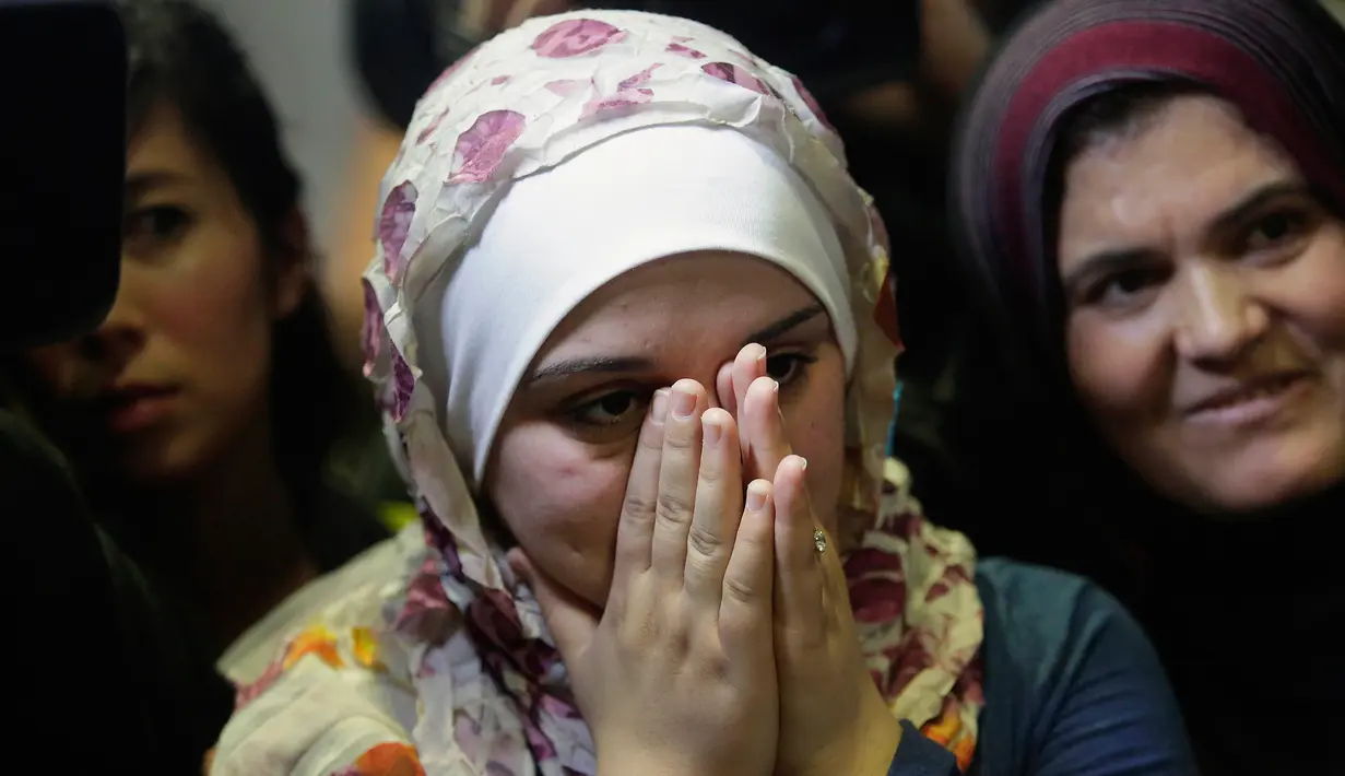 Ekspresi pengungsi asal Suriah Baraa Haj Khalaf tersenyum saat tiba di bandara Internasional O'Hare, AS, Rabu (7/2). Baraa dan keluarganya harus menjalani introgasi panjang agar bisa melewati otoritas bandara. (AFP Photo/ Scott Olson)