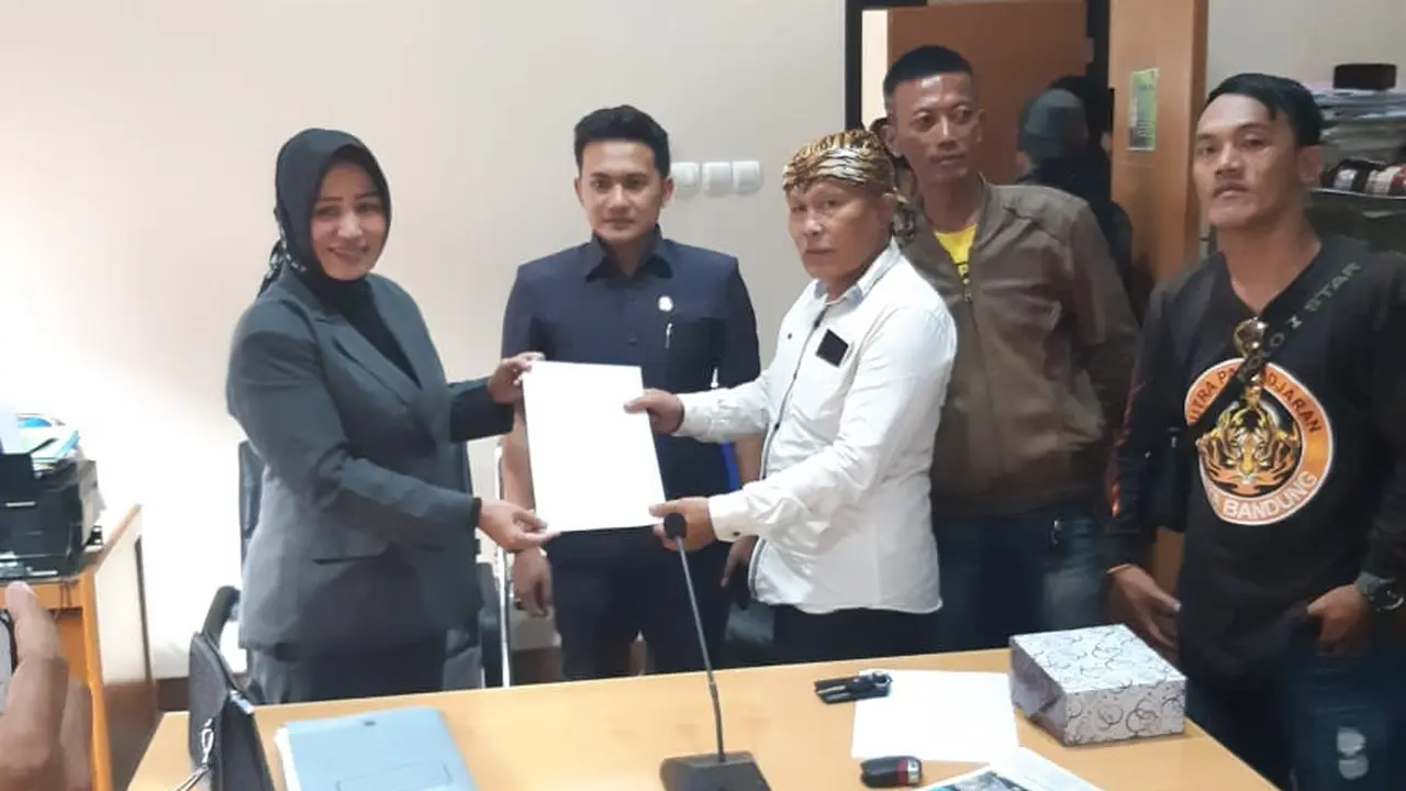 Kusna Kusdana, salah seorang calon kepala desa pemohon gugatan, tengah menerima berita acara penyerahan berkas gugatan saat audiensi ke DPRD Garut
