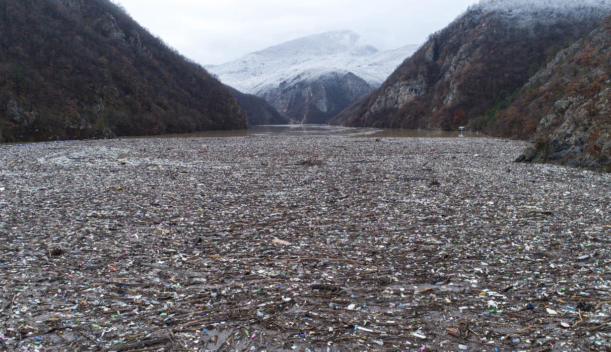 Sampah mengambang di sungai Drina dekat Visegrad, Bosnia, Jumat, 20 Januari 2023. Berton-ton limbah yang dibuang di tempat pembuangan sampah tepi sungai yang tidak diatur dengan baik atau langsung ke sungai-sungai di tiga negara Balkan Barat akhirnya menumpuk selama musim air tinggi di musim dingin dan musim semi, di belakang penghalang sampah di Sungai Drina, Bosnia timur. (AP Photo/Armin Durgut)