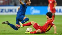 Bek Timnas Thailand, Theerathon Bunmathan ditekel oleh pemain Timnas Vietnam di Piala AFF 2020. (AFP/Roslan RAHMAN).