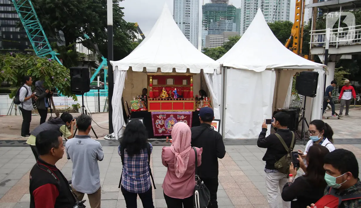 <p>Masyarakat tengah melihat pagelaran wayang potehi di Taman Budaya Dukuh Atas, Jakarta, Jumat (7/2/2020). Pagelaran pertunjukan wayang Tionghoa ini merupakan rangkaian kebudayan imlek yang di gelar oleh Pemprov DKI Jakarta. (Liputan6.com/Angga Yuniar)</p>