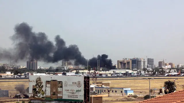 Asap tebal mengepul di atas gedung-gedung di sekitar bandara Khartoum pada 15 April 2023, di tengah bentrokan di ibu kota Sudan. (AFP)