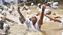 Pengikut Voodoo Haiti mandi di kolam suci selama upacara Voodoo di Souvenance, Haiti (4/1). Hingga kini Voodoo adalah salah satu dari tiga agama yang diakui di Haiti. (AFP/Hector Retamal)