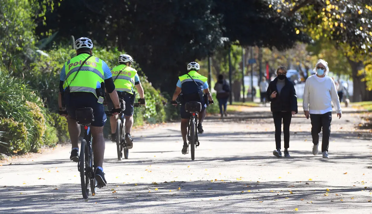 Polisi dengan sepeda berpatroli pada Rabu (2/6/2021). Kota Melbourne dan wilayah lainnya di negara bagian Victoria, Australia, akan mengalami perpanjangan lockdown yang tadinya dijadwalkan berakhir pada Kamis (3/6/2021) malam. (William WEST / AFP)