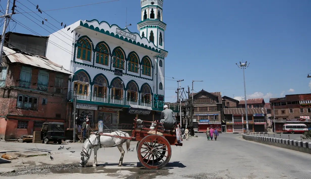 Seekor kuda minum air di jalan sepi selama penguncian di Srinagar, Kashmir yang dikuasai India (8/5/2020). Para ulama dan otoritas agama di bagian Kashmir India telah mendesak orang-orang untuk beribadah di dalam rumah mereka untuk mencegah penyebaran Covid-19 . (AP Photo/Mukhtar Khan)