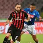 Penyerang AC Milan, Gonzalo Higuain menggiring bola dari kawalan gelandang Napoli, Allan saat bertanding pada lanjutan Liga Serie A Italia di San Paolo Stadium, Naples (25/8). Napoli menang tipis atas Milan 3-2. (AFP Photo/Alberto Pizzoli)