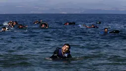 Seorang pengungsi Suriah tampak kelelahan saat berenang menuju pantai setelah perahu yang ditumpangi bocor sekitar 100 m sebelum mencapai pulau Lesbon, Yunani, Minggu (13/09/2015). (REUTERS/Alkis Konstantinidis)