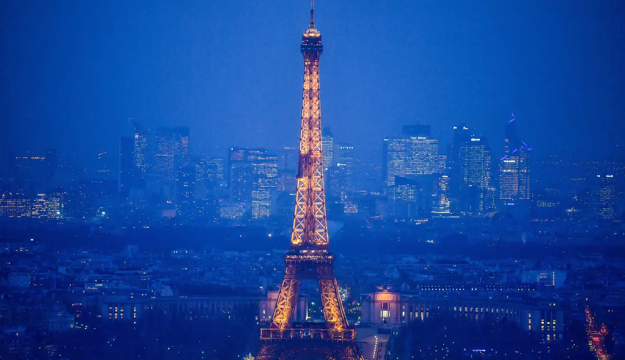 Lansekap kota Paris dari atap gedung pencakar langit "The Tour Montparnasse" memperlihatkan Menara Eiffel, Senin (8/1). Wisatawan dibuat tak percaya saat memandangi luasnya panorama kota saat malam yang bermandikan cahaya lampu. (CHRISTOPHE SIMON/AFP)