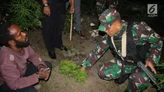 Danyonif Raider 756 Mayor Inf Arif Budi Situmeang menunjukkan pelaku pengedar ganja  Apianus Logo dan barang bukti di jalan lintas Wamena-Karubaga-Puncak Jaya di Kampung Kurulu, Papua, Jumat (3/8). (Liputan6.com/HO/Dispenad)