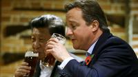 Perdana Menteri Inggris David Cameron (kanan) minum bir bersama Presiden China Xi Jinping di sebuah bar, Inggris, (22/10/2015). Di sela kunjungan ke Inggris, Presiden Cina Xi Jinping diajak PM David Cameron untuk minum bir. (REUTERS/Kirsty Wigglesworth)