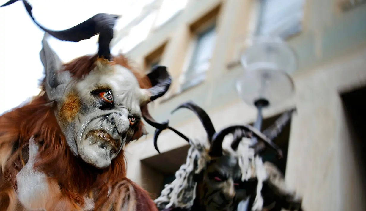 Sejumlah orang berkostum Krampuss selama parade di Munich, Jerman, Minggu (13/12). Dalam ceritanya Krampuss biasanya membawa cambuk hingga lonceng besar untuk menakut-nakuti anak-anak. (REUTERS/Michael Dalder)