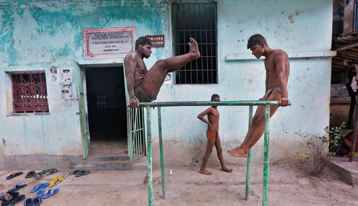 Dua pegulat saat berlatih di batang besi di pusat pelatihan gulat tradisional India di tepi Sungai Gangga menjelang Bengal kejuaraan gulat lumpur, di Kolkata, India 17 Mei 2016. (REUTERS / Rupak De Chowdhuri)
