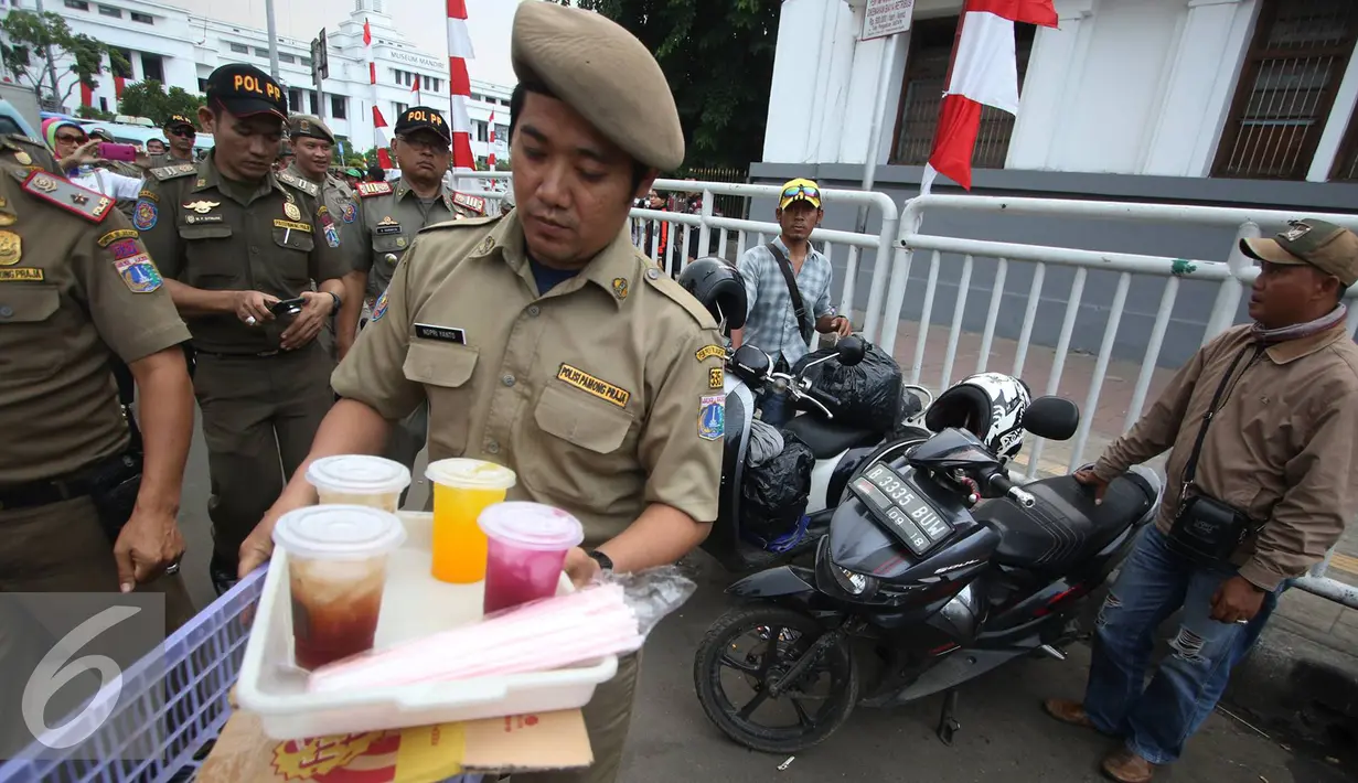 Petugas membawa minuman millik PKL di kawasan wisata Kota Tua, Jakarta, Rabu (24/8). Penertiban dilakukan guna membenahi PKL dan parkir liar yang kerap menimbulkan kesemrawutan di lokasi tersebut. (Liputan6.com/Immanuel Antonius)