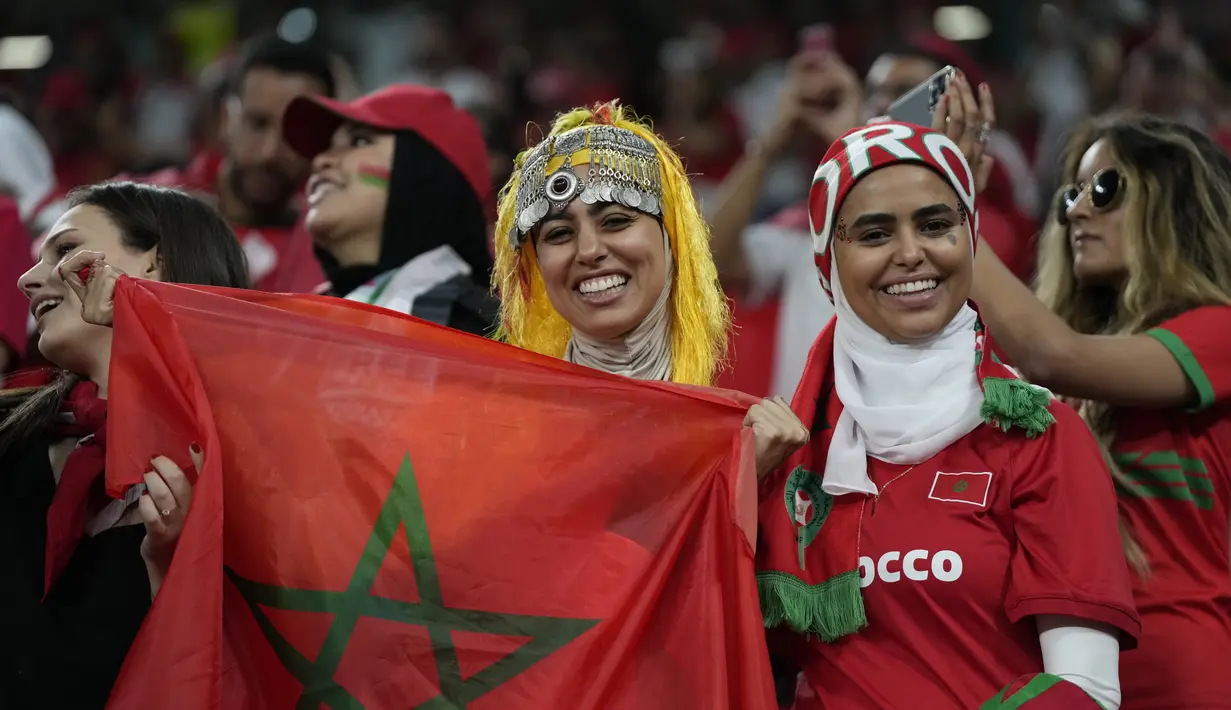 Para fans wanita Maroko tersenyum menunggu dimulainya pertandingan grup F Piala Dunia 2022 antara Kanada dan Maroko di Stadion Al Thumama di Doha, Qatar, Kamis, 1 Desember 2022. (AP Photo/Frank Augstein)