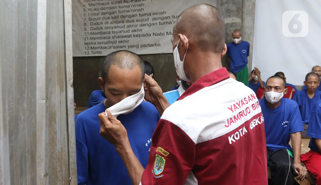 Petugas memakaikan makser ke pasien ODGJ saat mengikuti vaksinasi COVID-19 di Bekasi, Jawa Barat, Rabu (4/8/2021). Sebanyak 70 pasien ODGJ mengikuti kegiatan vaksinasi merdeka guna mencegah penyebaran wabah COVID-19. (Liputan6.com/Herman Zakharia)