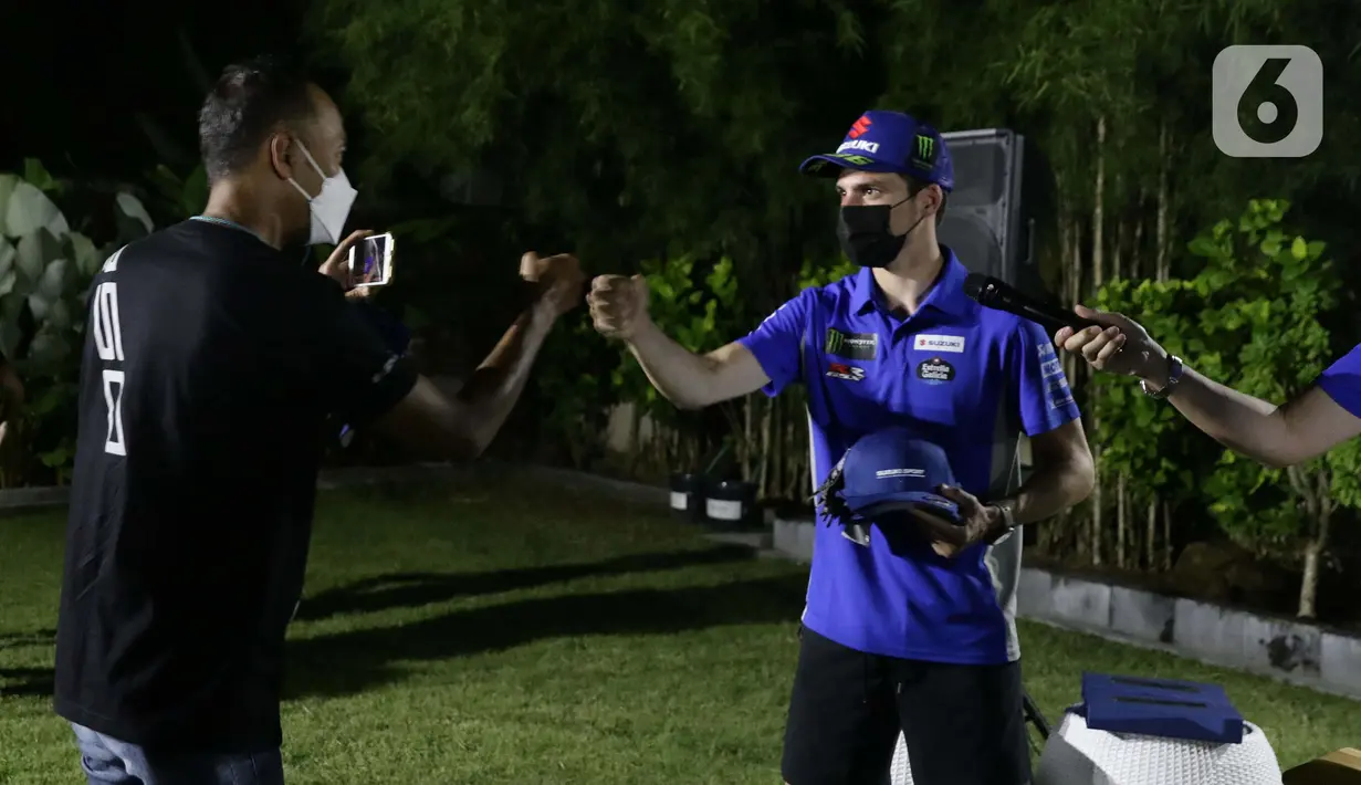 Pembalap Suzuki Ecstar, Joan Mir (kanan) memberi topi bertanda tangan usai Meet and Greet di Kuta Mandalika, Nusa Tenggara Barat, Jumat (18/3/2022). Joan Mir menjawab sejumlah pertanyaan terkait rangkaian Pertamina Grand Prix of Indonesia atau MotoGP Mandalika. (Liputan6.com/Helmi Fithriansyah)