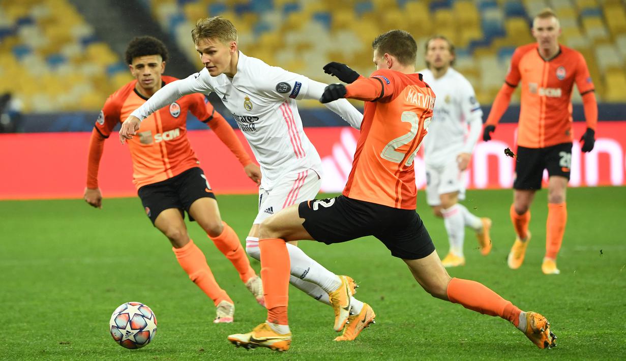 Gelandang Real Madrid, Martin Odegaard, berebut bola dengan bek Shakhtar Donetsk, Mykola Matviyenko, laga lanjutan Liga Champions di NSK Olimpiyskiy, Rabu (2/12/2020) dini hari WIB. Real Madrid kalah 0-2 oleh Shakhtar Donetsk. (AFP/Sergei Supinsky)